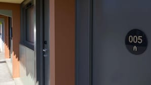 A hotel entrance with a door marked "005" and a window to the left. - Campanile NATURE - Le Mans Est (Le Mans)