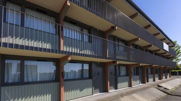 A multi-story building with balconies, large windows, and a flat facade.