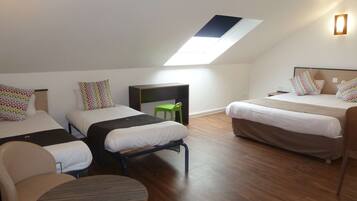 Une chambre avec deux lits, un bureau, une chaise et une petite table.