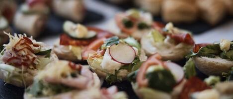 Una variedad de aperitivos, como sushi, ensaladas y sándwiches.
