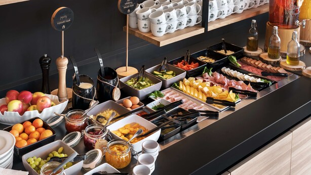 A buffet with various food items and utensils. - Campanile Katowice (Katowice)