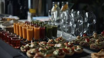 A buffet table with various food items and drinks.