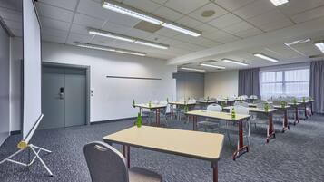 A conference room with tables and chairs, a projector, and a door.