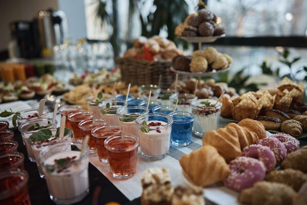 A buffet table with various food items and drinks.