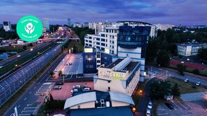 An aerial view of a hotel with a modern design, surrounded by a cityscape and a highway. - Campanile Katowice (Katowice)