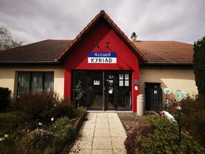 Een gebouw met een rode gevel en een bord waarop 