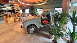 A vintage car in a shop with wooden crates and a ladder. - Birgit Hotel Le Havre Centre (Le Havre)
