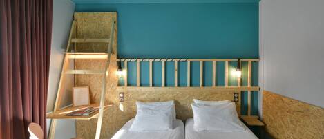 A hotel room with two beds, a wooden ladder, a desk with a chair, and a window with curtains.