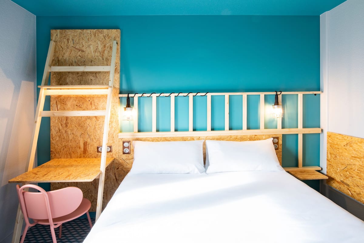 A room with a bunk bed, a desk with a chair, and a small table.