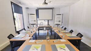 Un salón de conferencias con mesas largas, tarjetas de identificación, botellas de agua y acreditaciones.