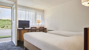 A hotel room with two beds, a desk with a computer, a lamp, and a TV. - Kyriad Direct Le Havre Est - Gonfreville (Gonfreville-l'Orcher)