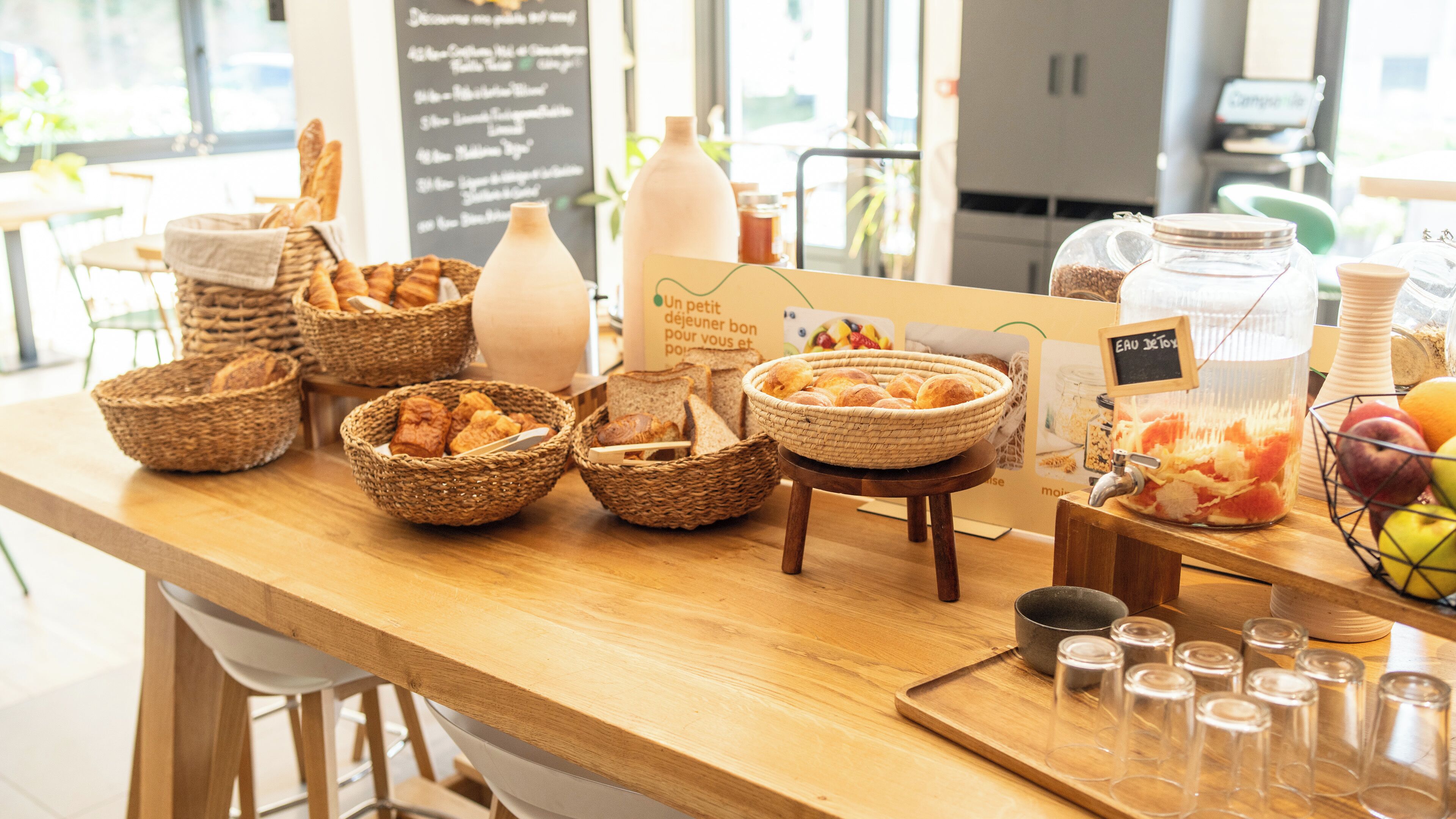 Un ricco buffet della colazione con pane, dolci e frutta assortiti.