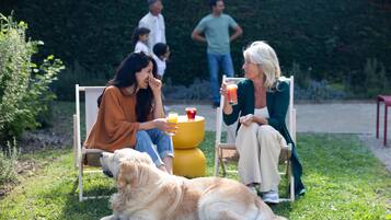A group of people sitting outdoors on chairs, with a dog lying in front of them.