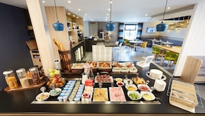 Un bufé con diferentes opciones de comida y una zona de estar con mesas y sillas.