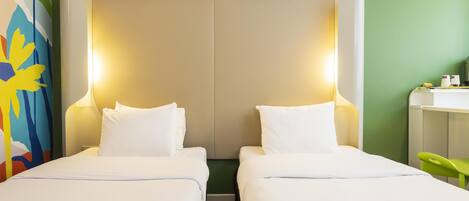 A hotel room with two beds, a green wall, and a colorful painting.