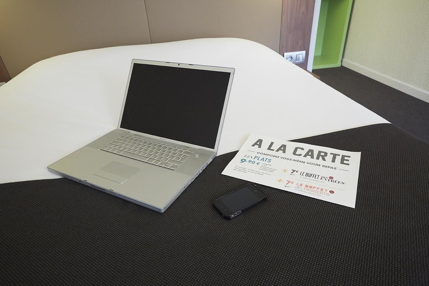A laptop on a white chair with a business card beside it.