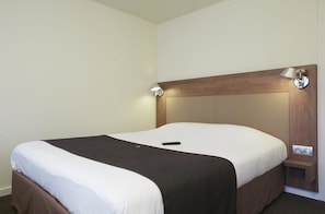 A hotel room with a bed, a bedside table, and a lamp. - Campanile Lille Sud-CHR (Lille)