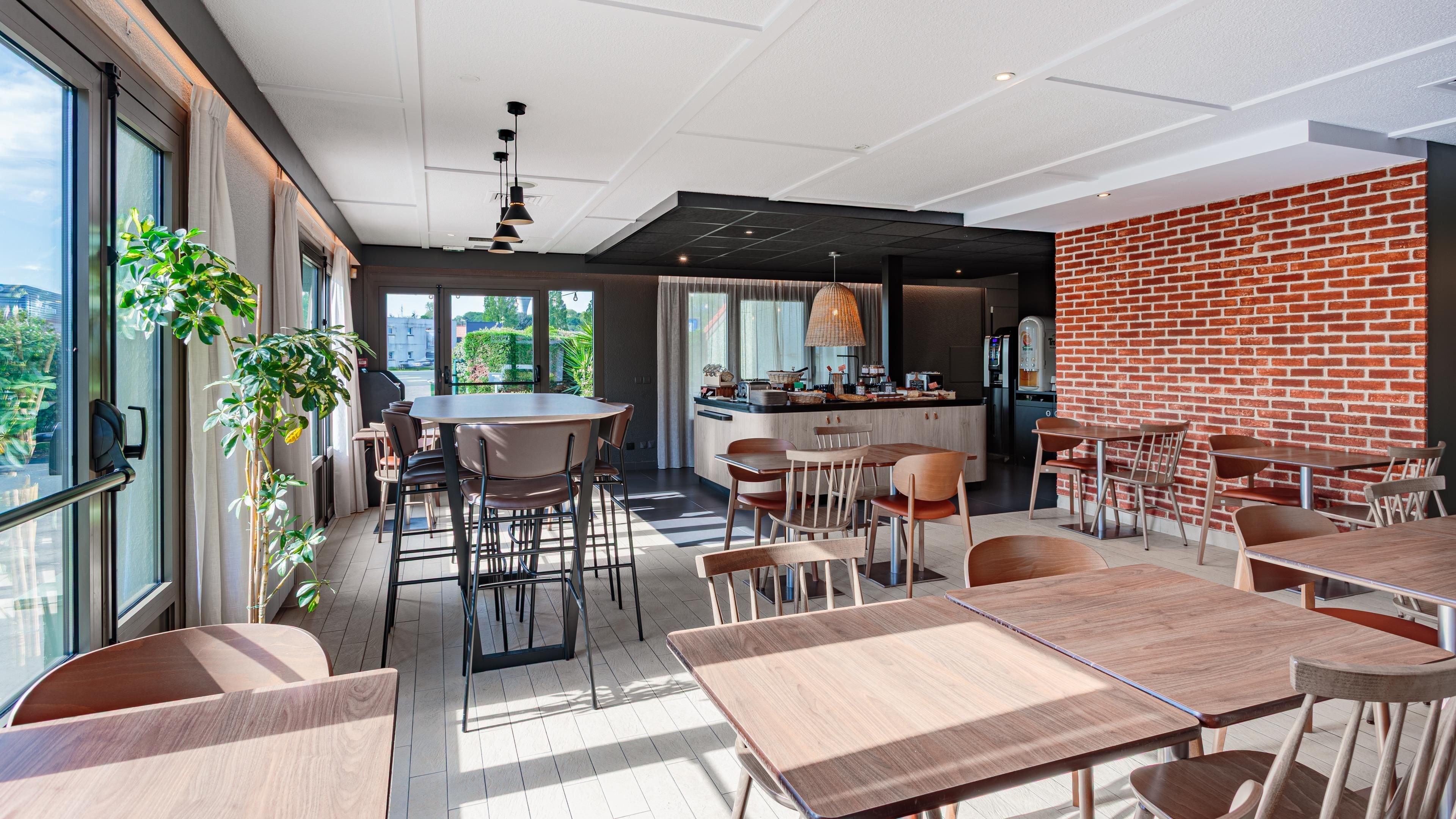A modern dining area with a brick wall, large windows, and a central island with seating.