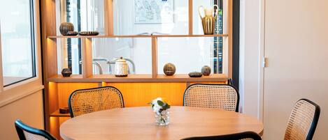 A dining area with a round table, four chairs, and hanging pendant lights.