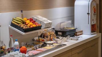 Ein reichhaltiges Buffet mit Früchten, Käse und Getränken.