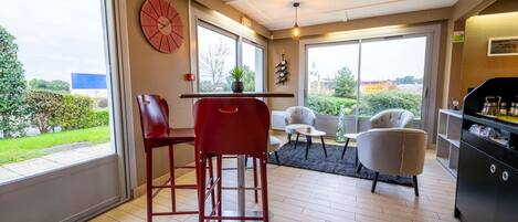 Una sala de estar moderna con comedor, ventanas amplias y vistas al exterior.