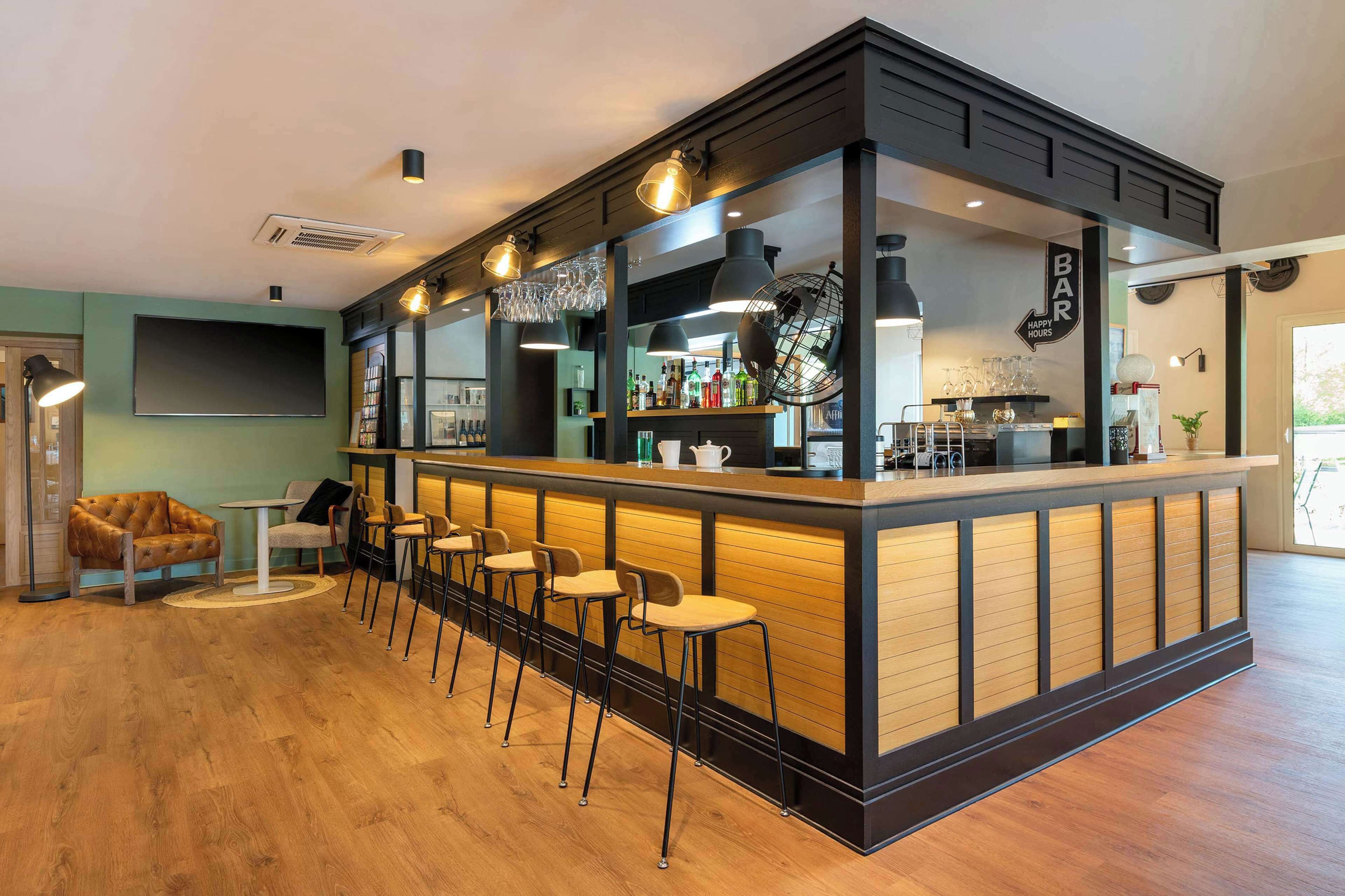 A bar area with a counter, stools, and a sign that reads "BAR Happy Hours".