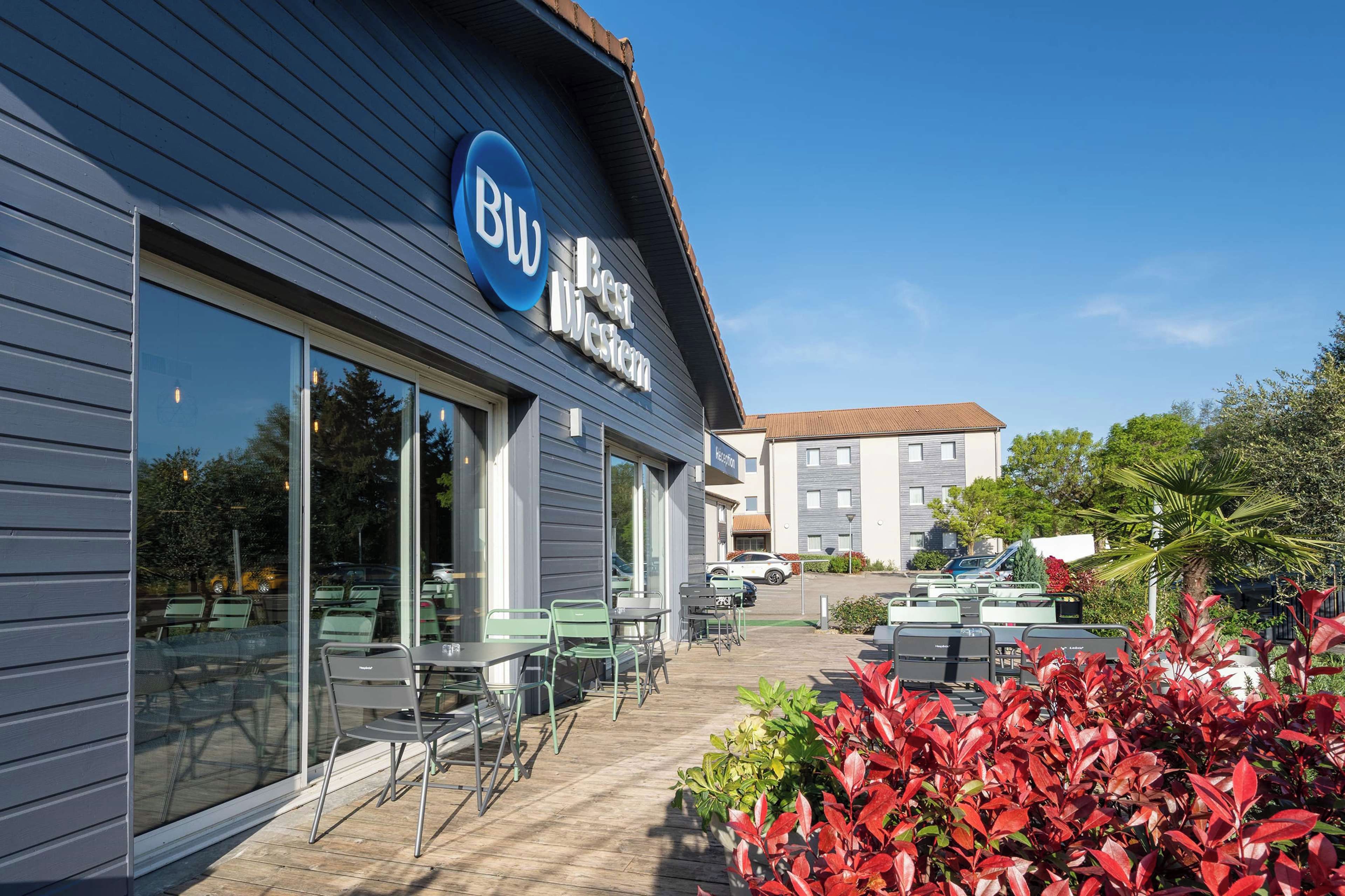 Ein Hotel mit blauem Schild, Außenbereich und Parkplatz.