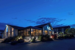 Vista frontal de la propiedad por la tarde o noche