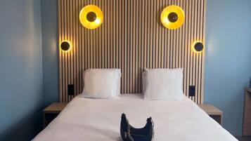 A hotel room with a large bed, two bedside tables, and a wall with vertical wooden slats.