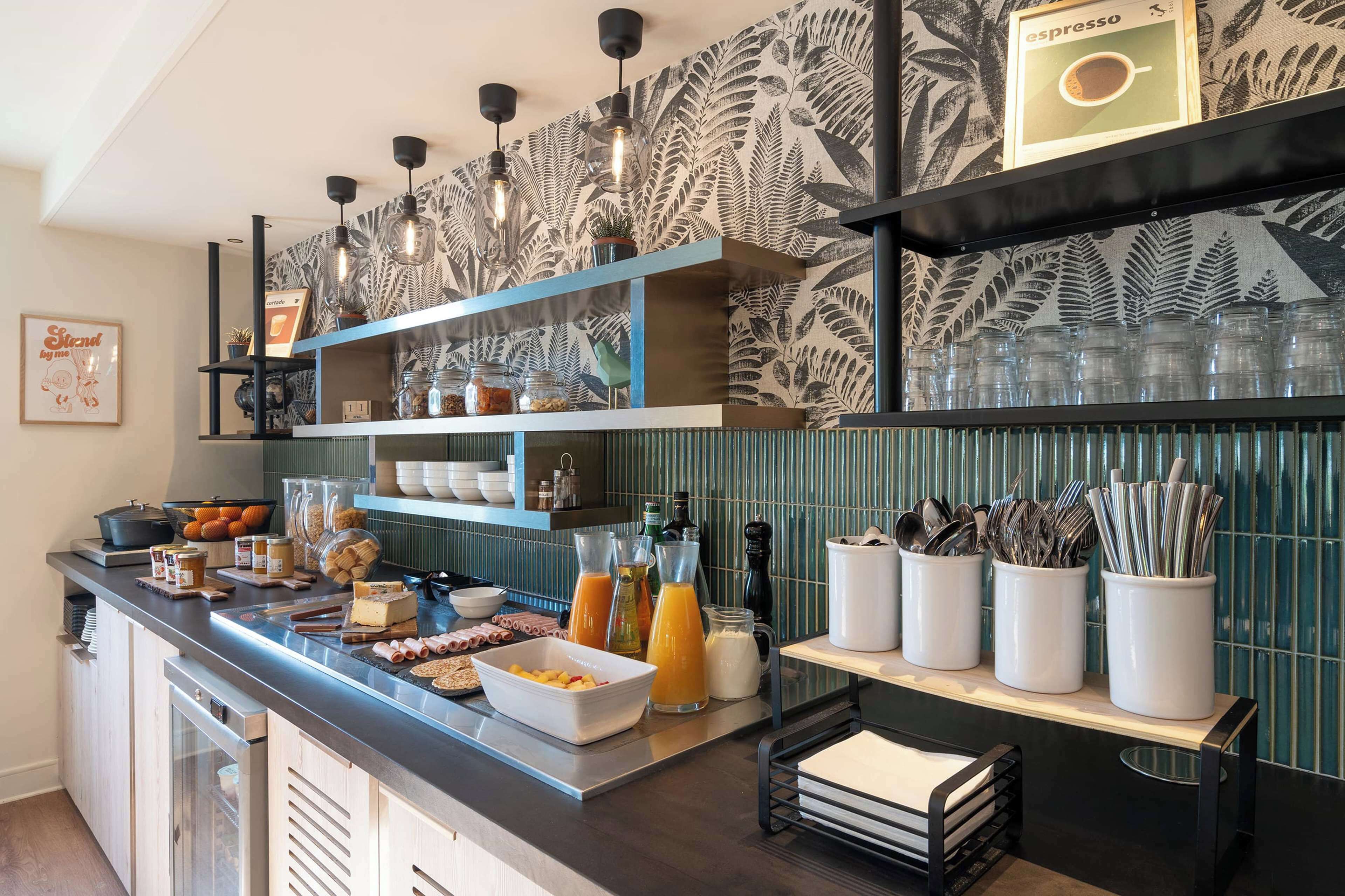 A breakfast bar with various food items, drinks, and utensils.