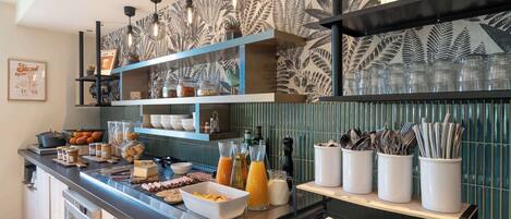 A breakfast bar with various food items, drinks, and utensils.
