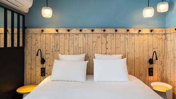 A hotel room with a wooden panel wall, a large bed with white bedding, two bedside tables with lamps, and a ceiling light fixture.