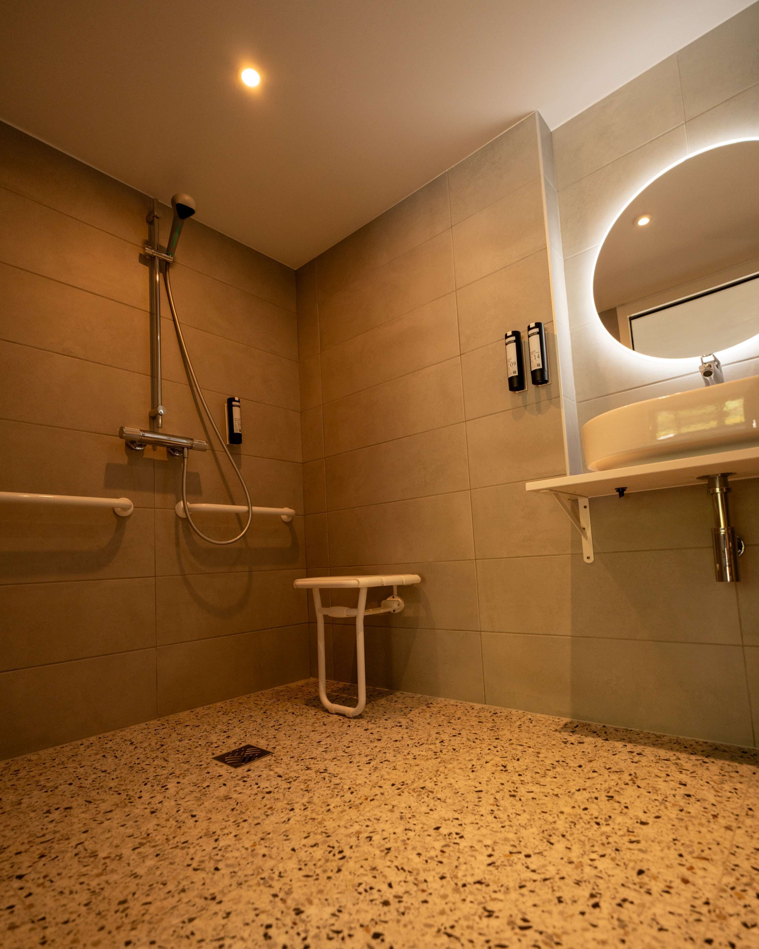 A modern bathroom with a shower, toilet, and sink.