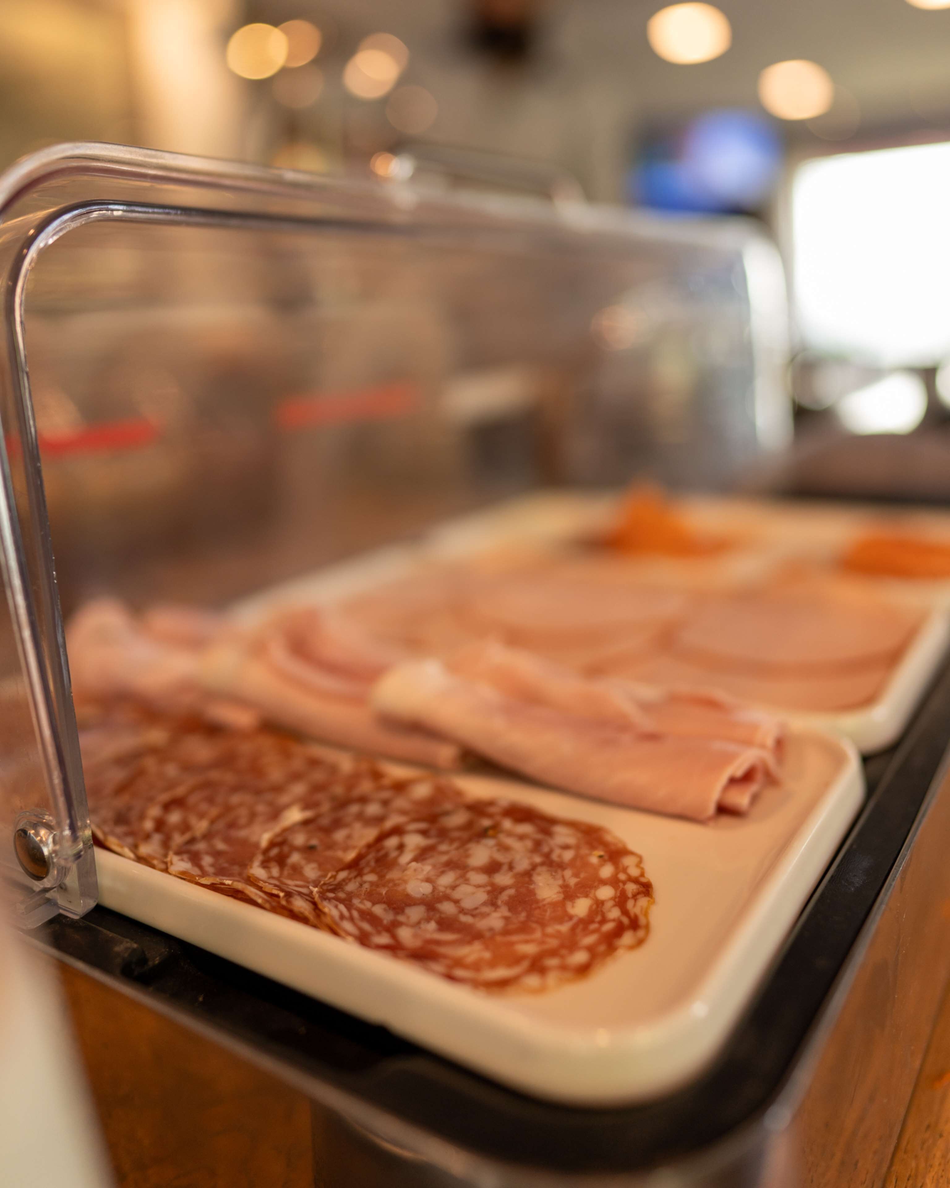 A deli counter with various meats displayed on a tray.