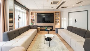 Un soggiorno moderno con due divani, un caminetto, una TV a schermo piatto e una libreria.