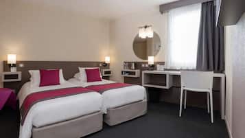 Habitación de hotel con dos camas, un escritorio, una silla, un espejo y una ventana con cortinas.