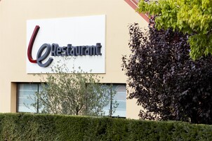 Un letrero de restaurante con una 'e' estilizada y la palabra 'Restaurant' sobre un fondo blanco.
