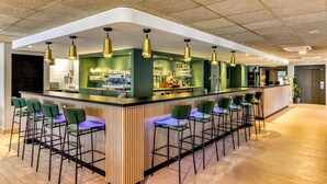 Un espace bar avec un comptoir, des tabourets et des luminaires suspendus.