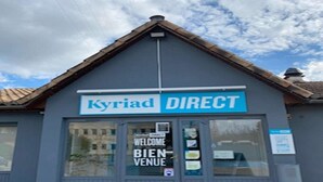 A building with a sign reading 'Kyriad DIRECT' and a welcome sign on the door.