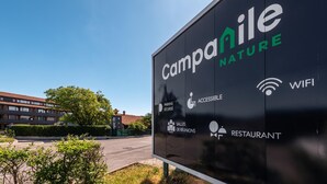 Señal de Campanile Nature que indica servicios como estacionamiento seguro, instalaciones accesibles, salas de reuniones, restaurante y WiFi.