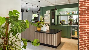 A reception area with a wooden counter, a printer, and a green wall.