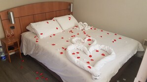 Habitación de hotel con una cama bien hecha, una mesita de noche con un vaso de agua y un calentador en la pared.