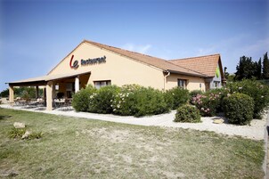Un restaurant doté d’une terrasse et d’un toit recouvert de tuiles.