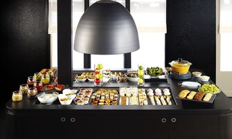 Une table de buffet garnie de divers plats et une grande lampe.