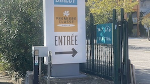 Een hotelschiltje voor 'Kyriad Direct' met een pijlpunt die de ingang aanwijst.