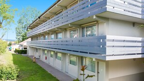 A modern multi-story hotel with a flat roof, large windows, and a covered outdoor area. - Hotel Campanile Mulhouse Sud - Morschwiller (Morschwiller-le-Bas)