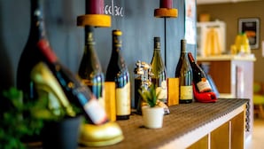 A bar counter with various bottles of wine and a small potted plant. - Hotel Campanile Mulhouse Sud - Morschwiller (Morschwiller-le-Bas)