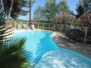 A swimming pool with clear blue water, surrounded by a white fence. There are lounge chairs along the poolside. - Kyriad Montpellier NORD - Parc Euromédecine (Saint-Clement-de-Riviere)