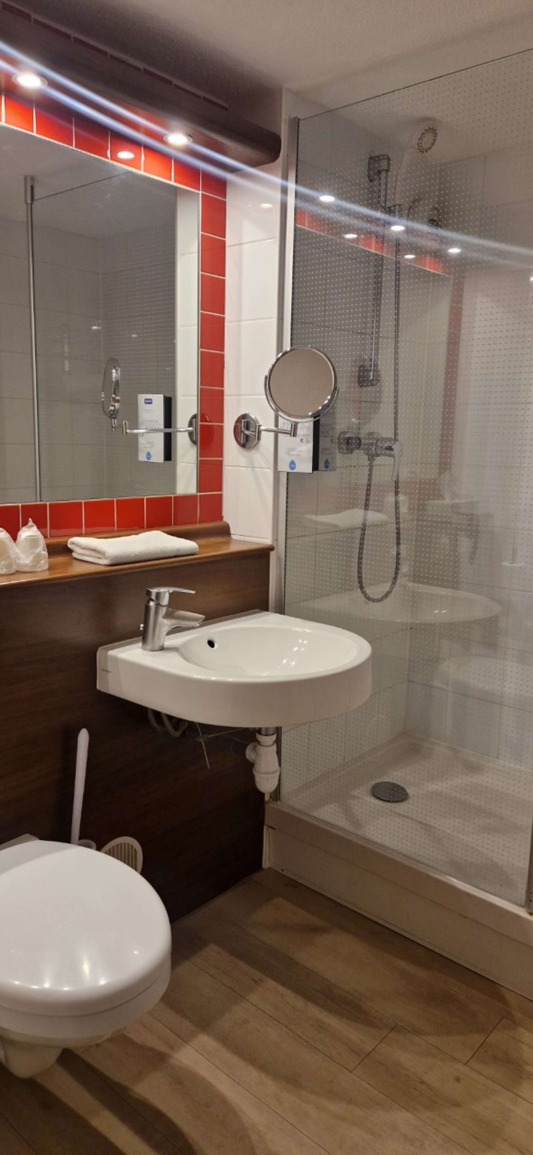 A modern bathroom with a shower, toilet, and sink.