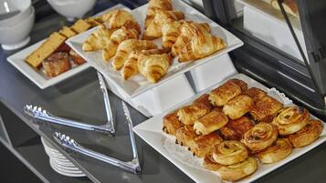 A buffet with various pastries and bread.